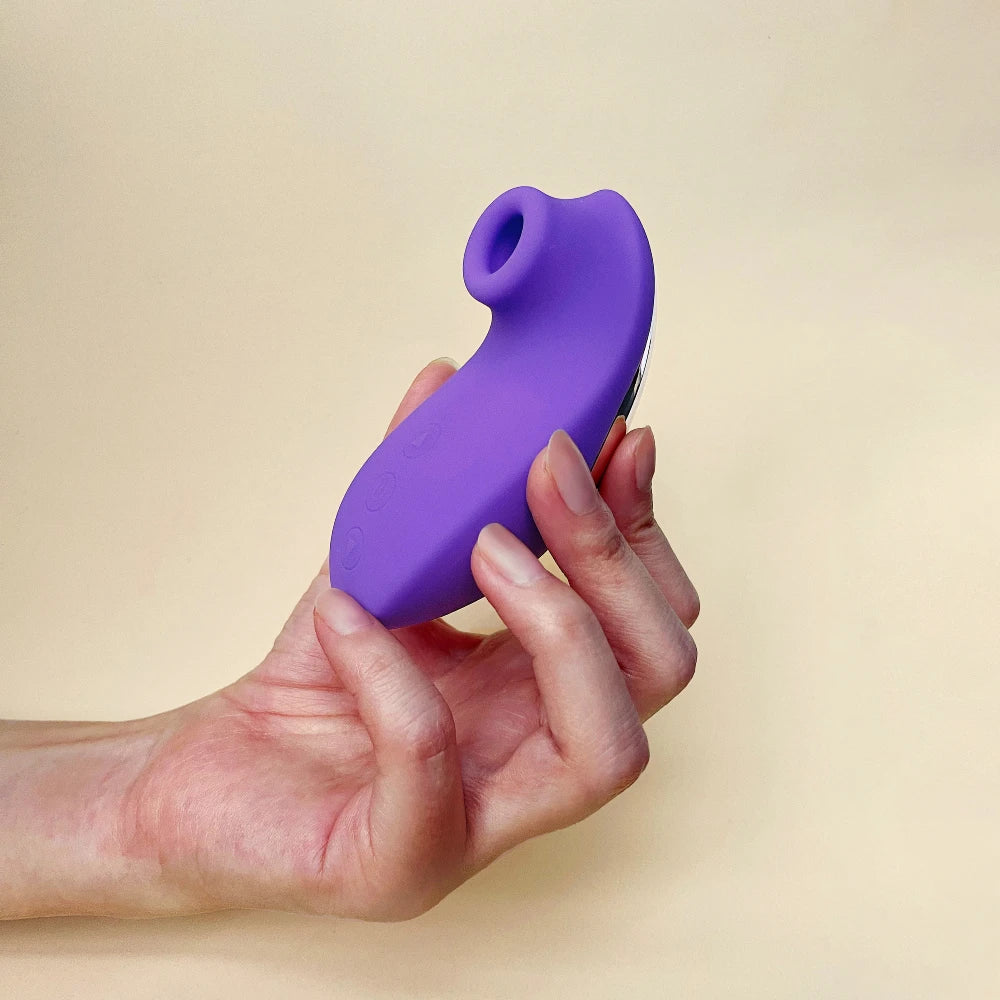Holding a purple clit stimulator in one hand