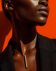 A Black model wearing a stylish vibrator necklace that doubles as a discreet bullet vibrator, mini vibrator, and bullet sex toy.