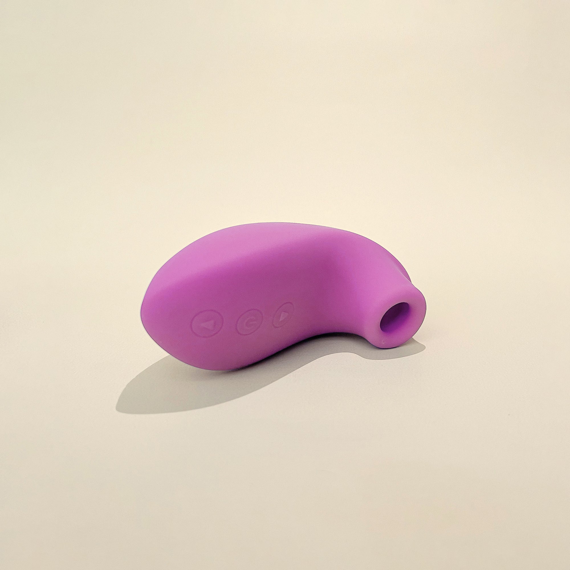 A pink clit stimulator placed on a flat surface