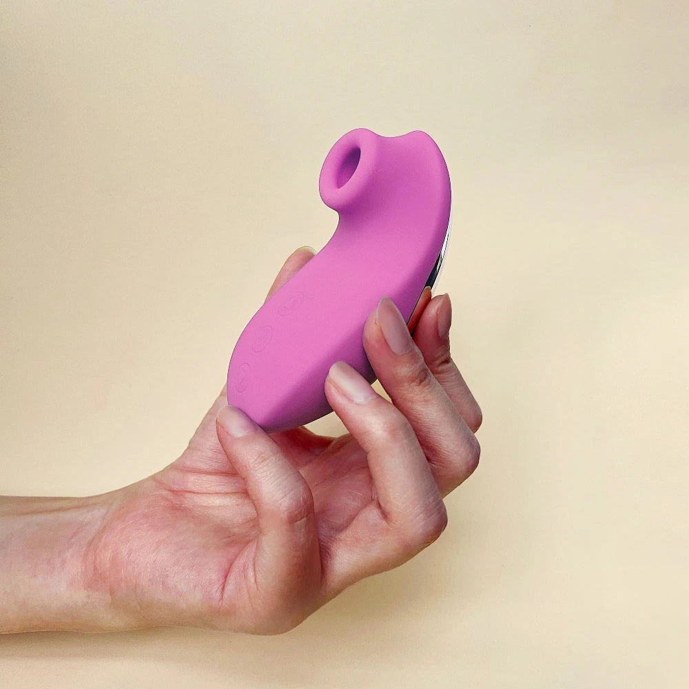 Holding a pink clit stimulator in one hand